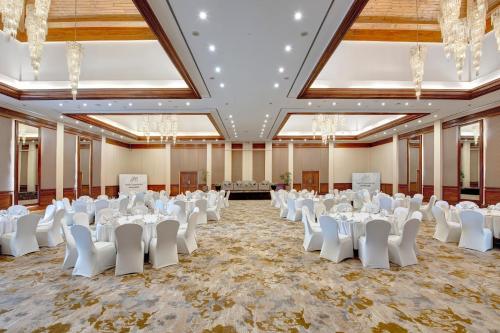 a banquet hall with white tables and chairs at Pearl Continental Hotel, Muzaffarabad in Muzaffarabad