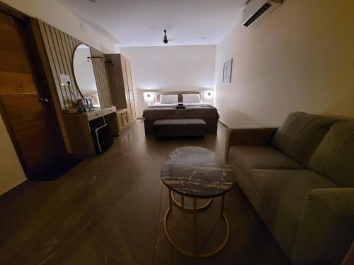 a living room with a couch and a bed at Aurora-The Pool Villa in Kozhikode