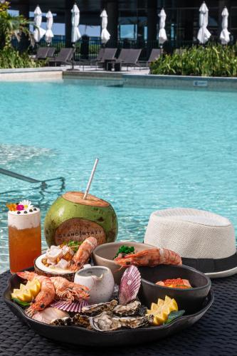 a tray of food on a table next to a pool at Grand Hyatt Rio de Janeiro in Rio de Janeiro