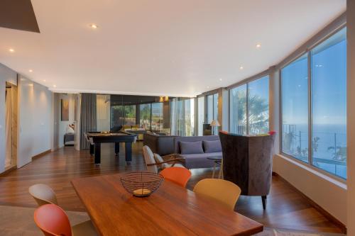 a living room with a couch and a table and chairs at A Porta das Neves in Funchal