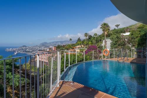 a swimming pool on a balcony with a view of the ocean at A Porta das Neves in Funchal