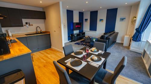 a kitchen and a living room with a table and chairs at Cardiff City Centre - Luxury Apartments in Cardiff