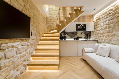 - un salon avec un mur en pierre et un canapé dans l'établissement B1 Beautiful, Luxury Near Eiffel Tower Sleeps AC, à Paris