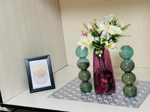 three vases sitting on a shelf with a picture and a frame at C-Rane Lodge in Phalaborwa