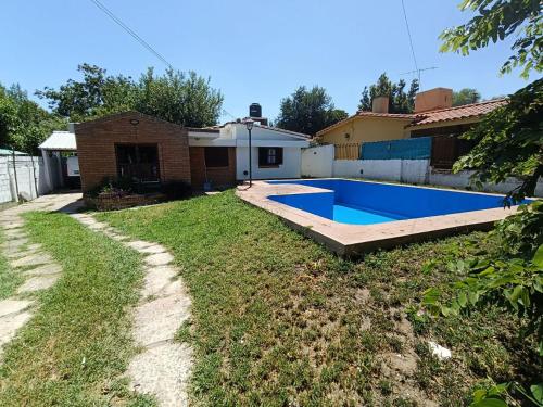 a backyard with a swimming pool and a house at Alojamiento Esparta in Villa Carlos Paz