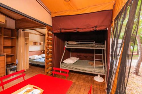 a bedroom with two bunk beds in a tent at Camping Onlycamp Le Petit Port in Châtel-Censoir