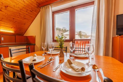 a dining room with a table and chairs and a window at Apartmány Novákovi in Dolní Morava