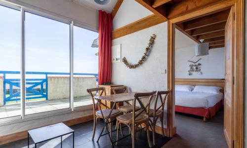 une chambre avec une table, des chaises et un lit dans l'établissement Eco-Domaine La Fontaine - RESIDENCE-SPA - Plage de la Fontaine aux Bretons, à Pornic