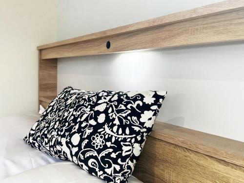 a black and white pillow sitting under a wooden shelf at 散步的喵 in Tung-chou