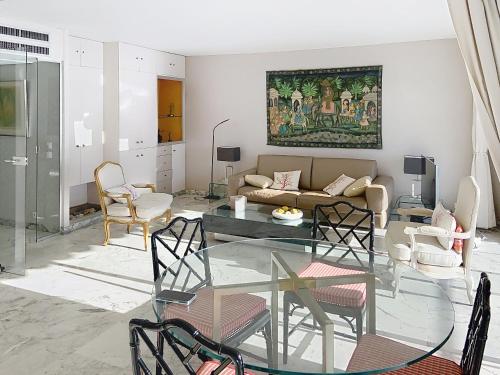 un salon avec une table en verre et des chaises dans l'établissement Situation & vue exceptionnelles, 134L FACQ, à Cannes