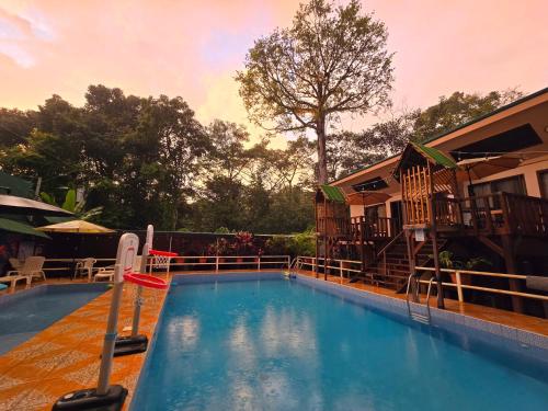 a swimming pool in front of a house at Cool Waters Jungle Villas in Uvita