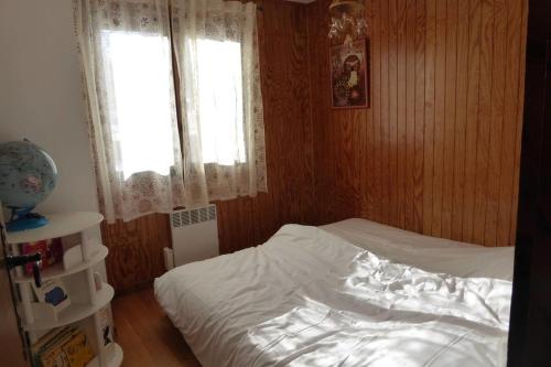 a bedroom with a white bed and a window at Chalet avec grand jardin en Chartreuse Alpes in Miribel-les-Échelles