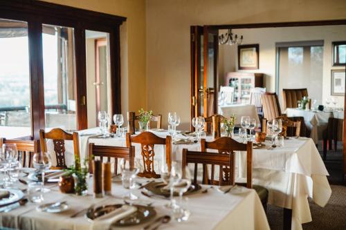 a dining room with tables and chairs with wine glasses at Hitgeheim Country Lodge in Addo