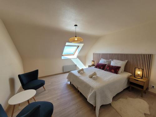 une chambre avec un grand lit et une fenêtre dans l'établissement Maison de la dune, vue mer et accès plage direct, à Plouescat