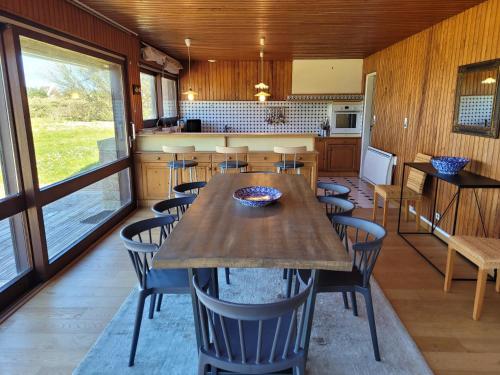 une cuisine et une salle à manger avec une table et des chaises dans l'établissement Maison de la dune, vue mer et accès plage direct, à Plouescat
