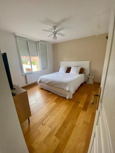 une chambre avec un lit et un ventilateur de plafond dans l'établissement Agréable maison proche 24h circuit et centre ville Pleasant house near circuit and city center, au Mans