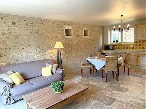 un salon avec un canapé et une table dans l'établissement Cottages Piscine Tennis 22pers, à Bourrou