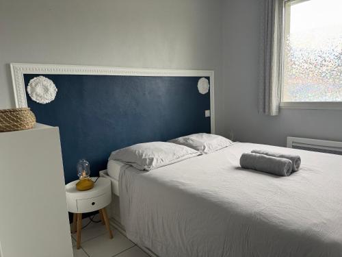 une chambre avec un grand lit avec une tête de lit bleue dans l'établissement ღ Le Prieuré - Avec Wifi, Terrasse & Parking, à La Rochelle