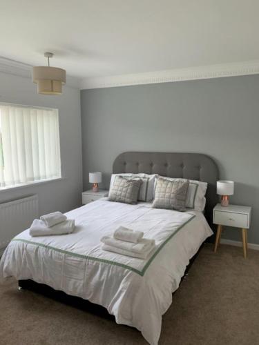 a white bedroom with a large bed with towels on it at Pallister House Middlesbrough in Middlesbrough