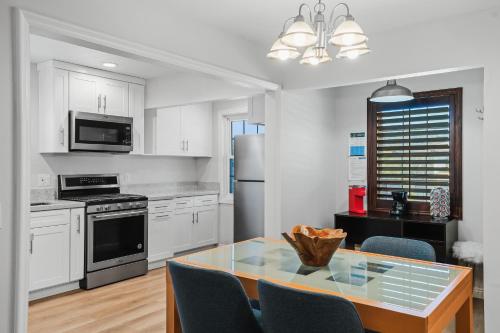 a kitchen with white cabinets and a table with chairs at Peaceful Getaway with Renovated Amenities in San Diego