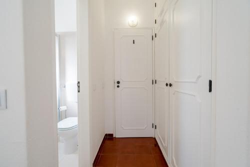 een badkamer met een toilet en een witte deur bij 5 bedroom Beach house in Luz, Lagos in Luz