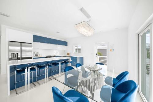 a kitchen with blue chairs and a glass table at Azul Paradise - Waterfront - Heated Pool - Dock in Marathon