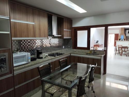 a kitchen with a glass table and some chairs at Pousada Araúna Angra in Angra dos Reis