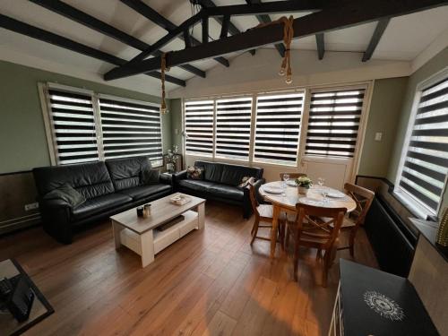 a living room with a couch and a table at Vakantiebungalow 95 in Baarland in Baarland