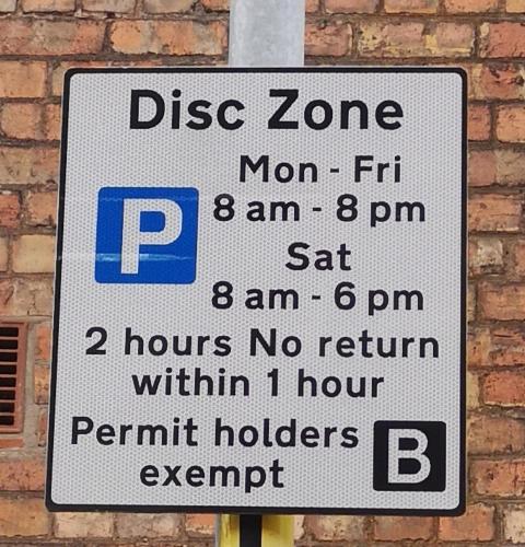 a street sign on a pole next to a brick wall at Carlisle Homestay - Double Room in Carlisle
