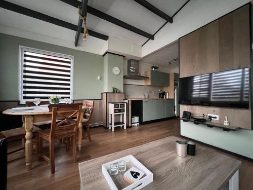 a living room with a table and a kitchen at Vakantiebungalow 95 in Baarland in Baarland