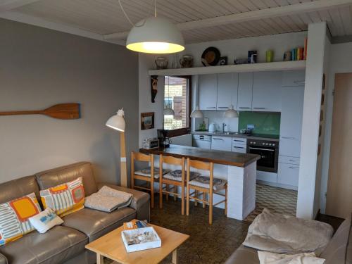 a living room with a couch and a kitchen at Ferienhaus Marienleuchte in Marienleuchte