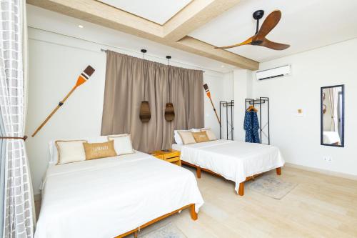 a bedroom with two beds and a ceiling at Serenity Residences & Spa - Kokrobite Beach in Kokrobite