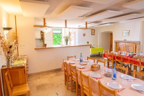 une grande chambre avec une grande table et des chaises dans l'établissement L'etape 11 personnes du couvent, à Saint-Georges-de-Lévéjac