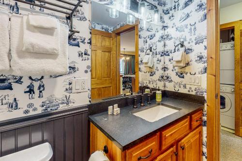 a bathroom with a sink and a blue and white wallpaper at Jay Peak Village Home 375 in Jay