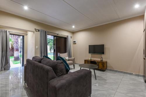 a living room with a couch and a tv at Serenity Amarula in Sandton