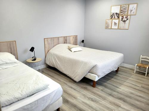 ein Schlafzimmer mit zwei Betten und einem Tisch und einem Stuhl in der Unterkunft La villa Kikifil, bord de mer in Saint-Germain-sur-Ay