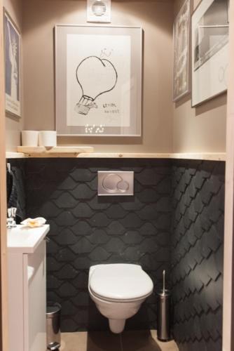 La salle de bains est pourvue de toilettes et d'une photo d'une tête sur le mur. dans l'établissement Les Fermes De Pinpin, à Labaroche