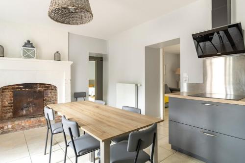 une cuisine et une salle à manger avec une table et des chaises en bois dans l'établissement Domaine de la Garnauderie Gîte des Chênes, à Sainte-Maure-de-Touraine
