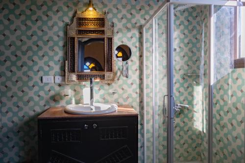 a bathroom with a sink and a mirror and a shower at Laziza in Luxor