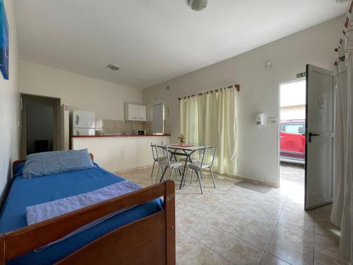 een slaapkamer met een bed en een tafel met stoelen bij Portal del Mar in Las Grutas