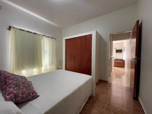 een slaapkamer met een bed en een deur naar een gang bij Portal del Mar in Las Grutas