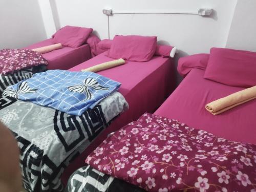 a room with two beds with covers on them at Grand Square Hostel Luxor in Luxor