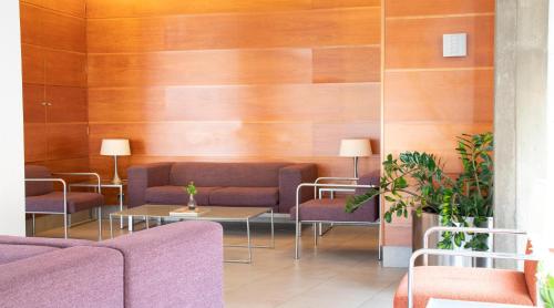 a waiting room with purple furniture and wooden walls at Port Feria Valencia in Valencia