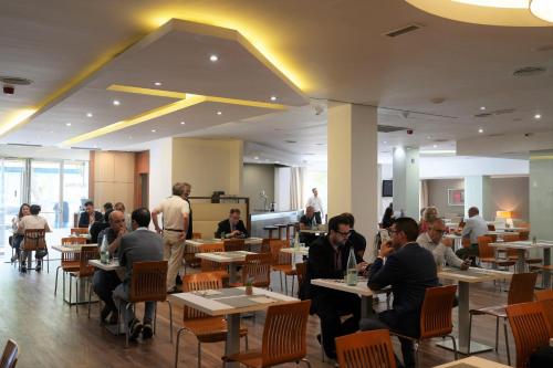 a group of people sitting at tables in a restaurant at Port Feria Valencia in Valencia