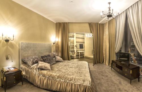 um quarto com uma cama grande e uma televisão em Vysotsky Hotel em Ecaterimburgo