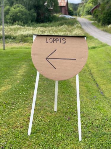 a sign with an arrow on it in the grass at Cozy guest house in the countryside in Håltebyn