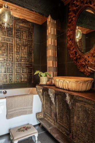 a bathroom with a tub and a mirror and a sink at Cozy guest house in the countryside in Håltebyn