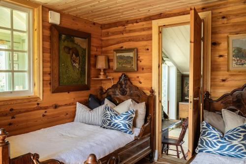 a bedroom with a bed with blue and white pillows at Cozy guest house in the countryside in Håltebyn