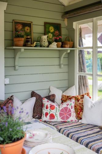 a couch with pillows on it in a room at Cozy guest house in the countryside in Håltebyn