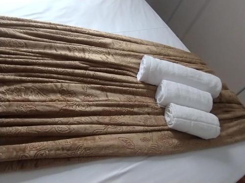 a bundle of towels sitting on top of a bed at Casa do Anderson in Guarulhos